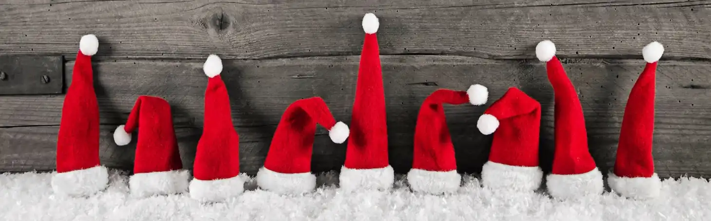 Nikolaus-Mützen vor Holzwand