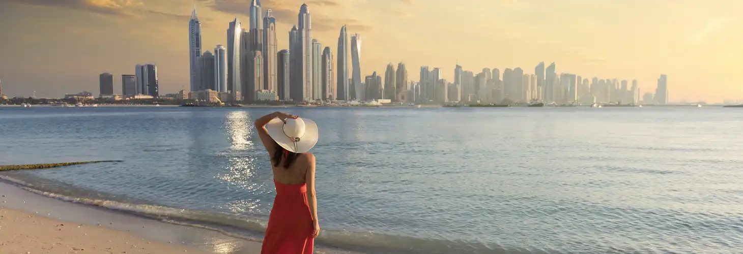 Frau in rotem Kleid vor Skyline von Dubai