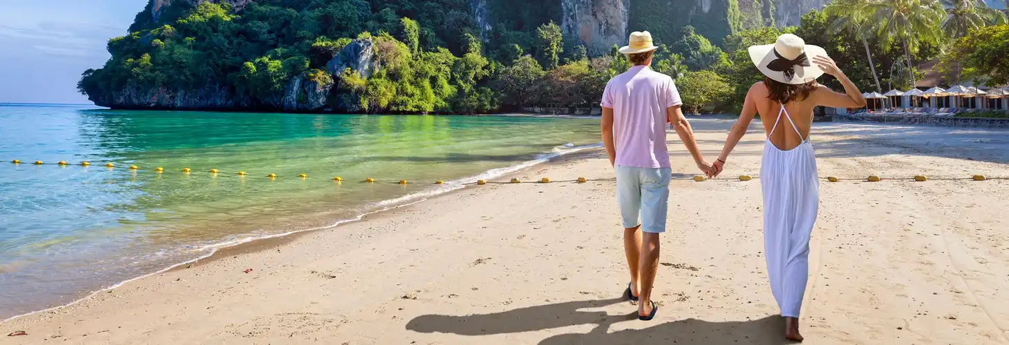 Paar spaziert am Strand in Thailand