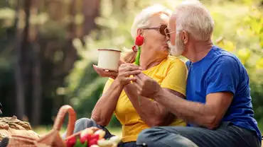 Eine Frau und ein Mann die beim Picknick im Wald sitzen