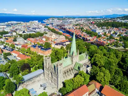 Luftaufnahme einer Stadt mit einer großen Kathedrale und umliegender grüner Landschaft.