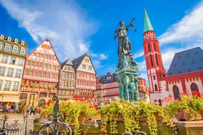 Historische Fachwerkhäuser und Brunnen auf einem Platz in Frankfurt.
