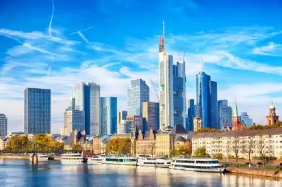 Frankfurter Skyline am Mainufer mit modernem Wolkenkratzer-Ensemble bei klarem Himmel.