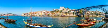 Fluss und Stadtpanorama von Porto mit traditionellen Booten und der Brücke Dom Luís I.