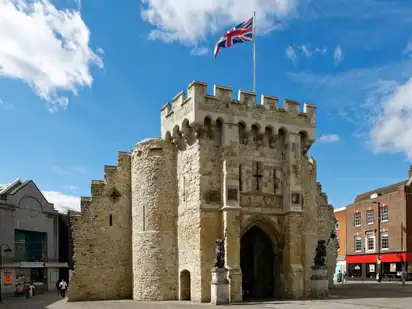 Historisches Steintor mit britischer Flagge und blauem Himmel.