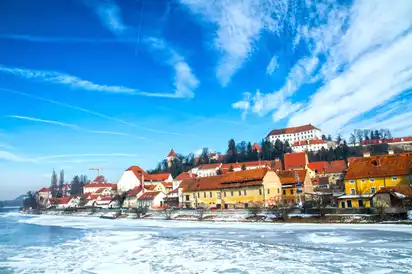 Gefrohrener Fluss Drava mit Blick auf die Stadt Ptuj, Slowenien