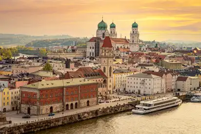 Stadtansicht von Passau mit Donau und Dom bei Sonnenuntergang.