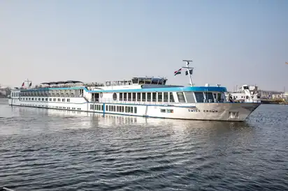 Kreuzfahrtschiff Swiss Crown auf einem Fluss bei klarem Himmel.