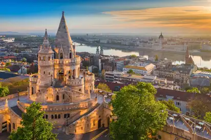 Fischerbastei in Budapest bei Sonnenuntergang mit Blick auf die Donau und das Parlament.