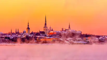 Stadtansicht mit Kirchtürmen im Sonnenuntergang.