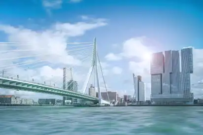 Stadtbild von Rotterdam mit Erasmusbrücke und modernen Gebäuden am Wasser.
