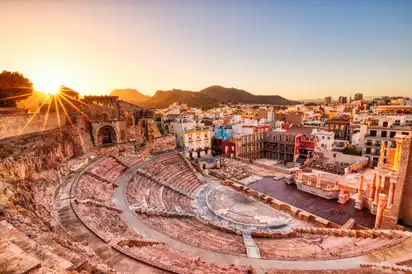 Römisches Theater in Cartagena bei Sonnenuntergang, mit Blick auf die umliegende Hafenstadt in der Region Murcia, Spanien.