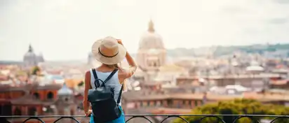 Eine Frau mit Hut und Rucksack genießt die Aussicht auf die Skyline von Rom, Italiens Hauptstadt.