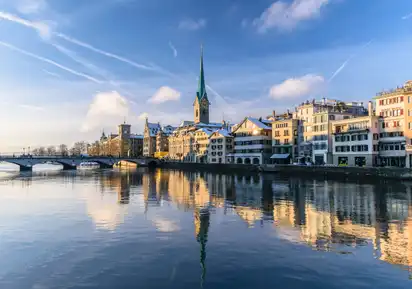 Zürich im Winter mit Blick auf die Limmat und historische Gebäude am Flussufer.