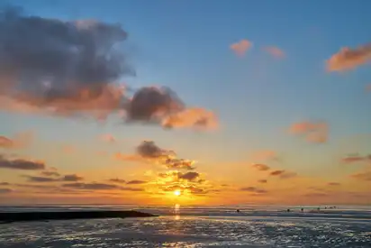 Sonnenuntergang am Meer mit Wolken am Himmel