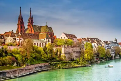 Basel am Rheinufer mit der Basler Münster im Hintergrund an einem sonnigen Tag.