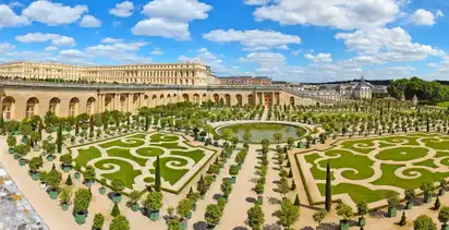Barockgarten mit symmetrischen Hecken und einem zentralen Brunnen.