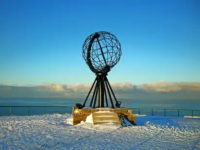 Monument am Nordkap mit Globus-Skulptur im Schnee.