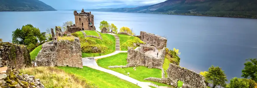 Urquhart Castle mit Dark Cloud Sky und Loch Ness im Hintergrund