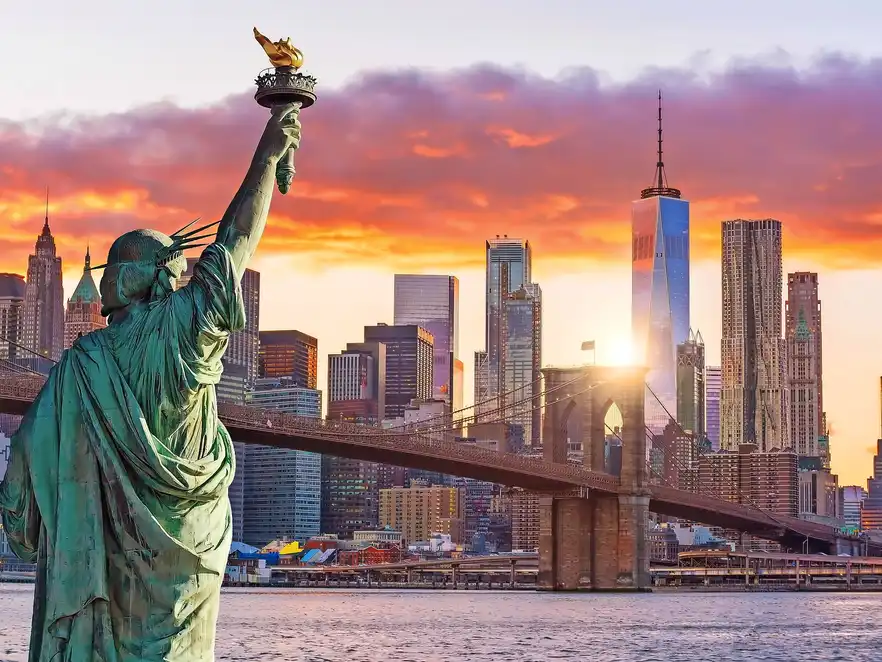Statue Liberty and  New York city skyline at sunset