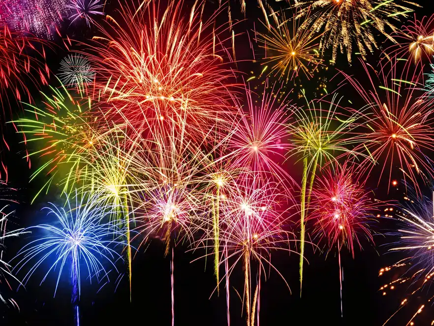 Knalliges Feuerwerk mit Feierstimmung, lebhafte Farben auf schwarzem Hintergrund